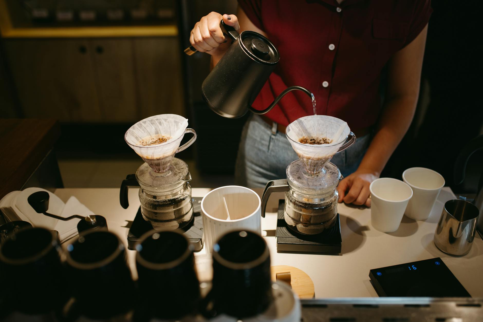 Barista gießt Kaffee per Handaufbrühung